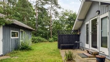 A residential property with a fenced backyard, a small shed, and a patio area with a table and chairs.