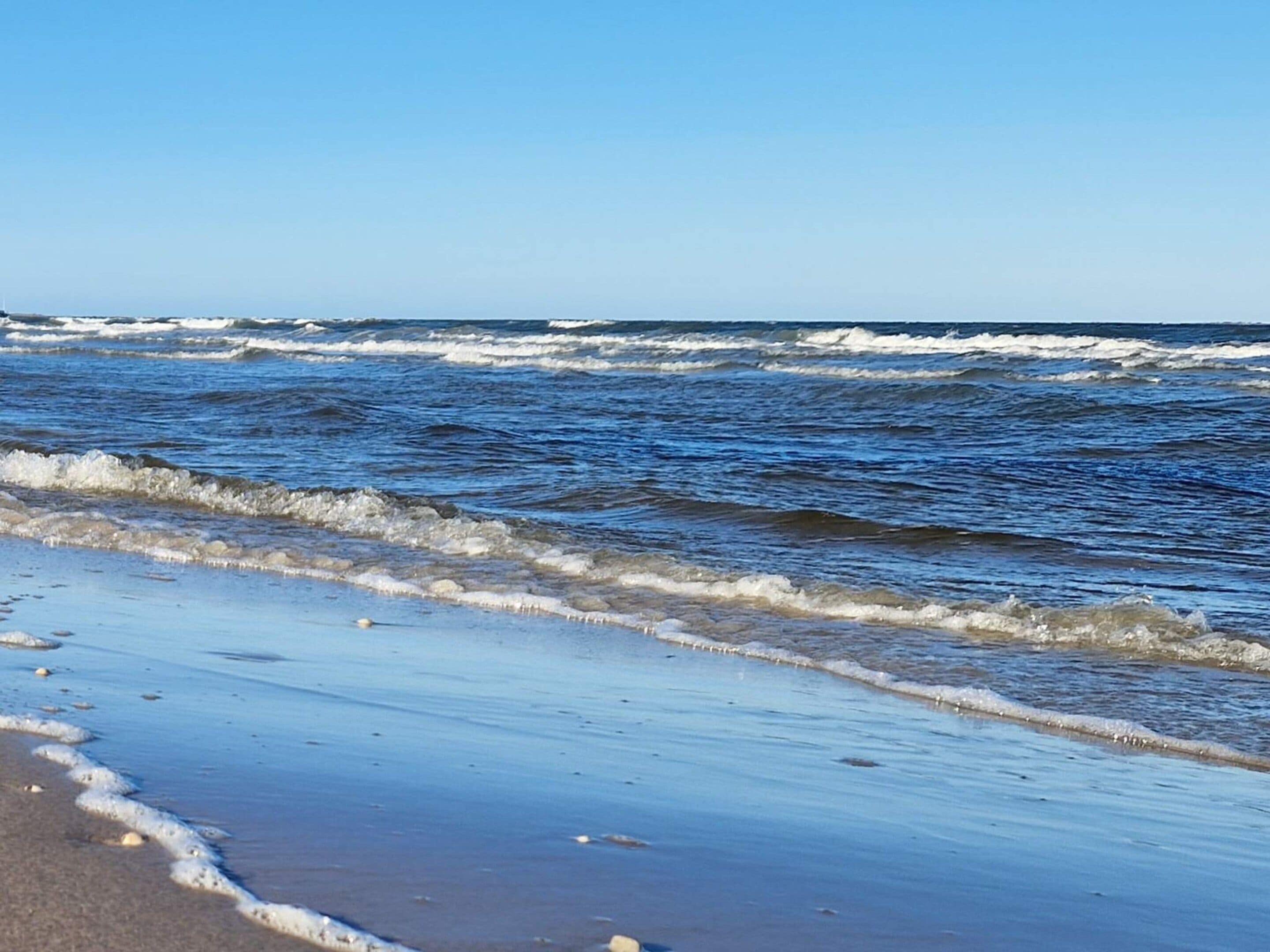 Una playa con olas acercándose a la orilla.