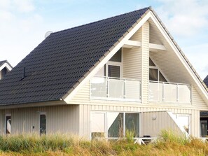 A coastal building with a gabled roof, large windows, and a balcony. - Holiday Home in Wendtorf (Wendtorf)