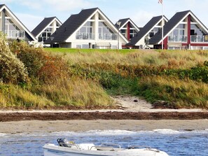 A row of houses with a beach in the foreground.