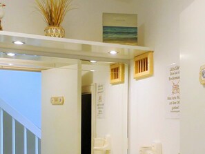 A hotel bathroom with a mirror, a towel rack, and a sign with German text. - Holiday Home in Wendtorf (Wendtorf)