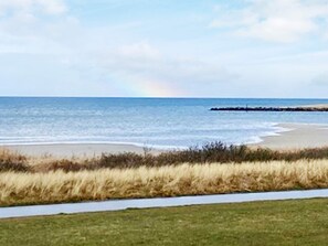 A beach with a grassy area and a path leading to the water. - Holiday Home in Wendtorf (Wendtorf)