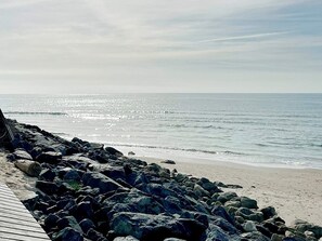 Une côte rocheuse avec une promenade en bois qui mène à la plage.