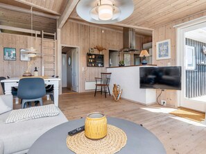 A modern living room with a TV, sofa, and dining area. - 5 Star Holiday Home in Hjorring (Hjørring)