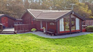A red wooden building with a sloped roof, a porch with a bench, and a sign that reads "Schranken". - 6 Person Holiday Home in Vestervig (Vestervig)