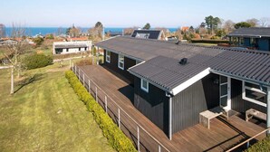 A modern house with a large deck, a covered outdoor area, and a view of the sea. - 6 Person Holiday Home in Allingabro-by Traum (Allingåbro)