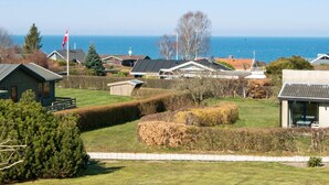 A coastal residential area with houses, a flag, and a view of the sea. - 6 Person Holiday Home in Allingabro-by Traum (Allingåbro)
