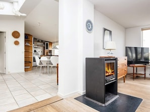A modern living room with a fireplace, a television, and a dining area. - 6 Person Holiday Home in Borkop (Borkop)