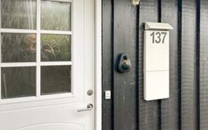 A door with a window, a doorbell, and a mailbox with the number 137.