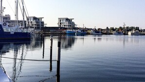 A marina with boats docked, a clear sky, and buildings in the background. - Holiday Home in Wendtorf (Wendtorf)