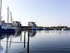 A marina with boats docked, a clear sky, and buildings in the background. - Holiday Home in Wendtorf (Wendtorf)