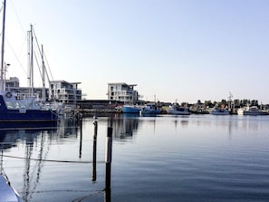 A marina with boats docked, a clear sky, and buildings in the background. - Holiday Home in Wendtorf (Wendtorf)
