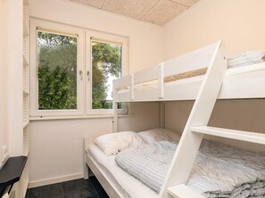 Een stapelbed met een raam erboven, een bureau en een stoel.