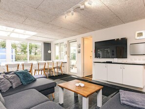 Un salon moderne avec un canapé, une table basse et un téléviseur.