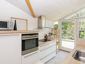 A modern kitchen with a built-in oven, microwave, and stainless steel sink.