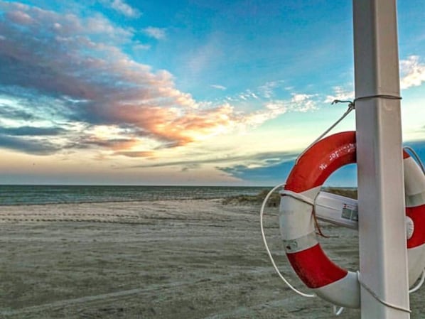 A lifebuoy attached to a pole by the beach.