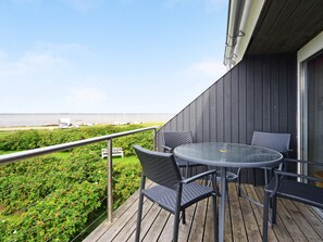 A balcony with a table and chairs, overlooking a body of water and greenery. - Quaint Holiday Home in Hemmet near Fjord (Hemmet)