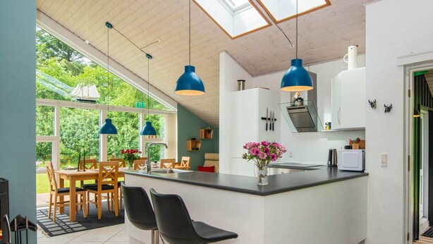 A modern kitchen with a central island, bar stools, and pendant lighting. - 8 Person Holiday Home in Brovst (Brovst)