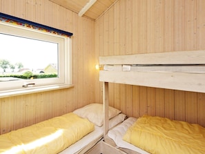 A room with two bunk beds, a window with a view of the outside, and a wooden ceiling. - 4 Star Holiday Home in Sjolund (Sjølund)