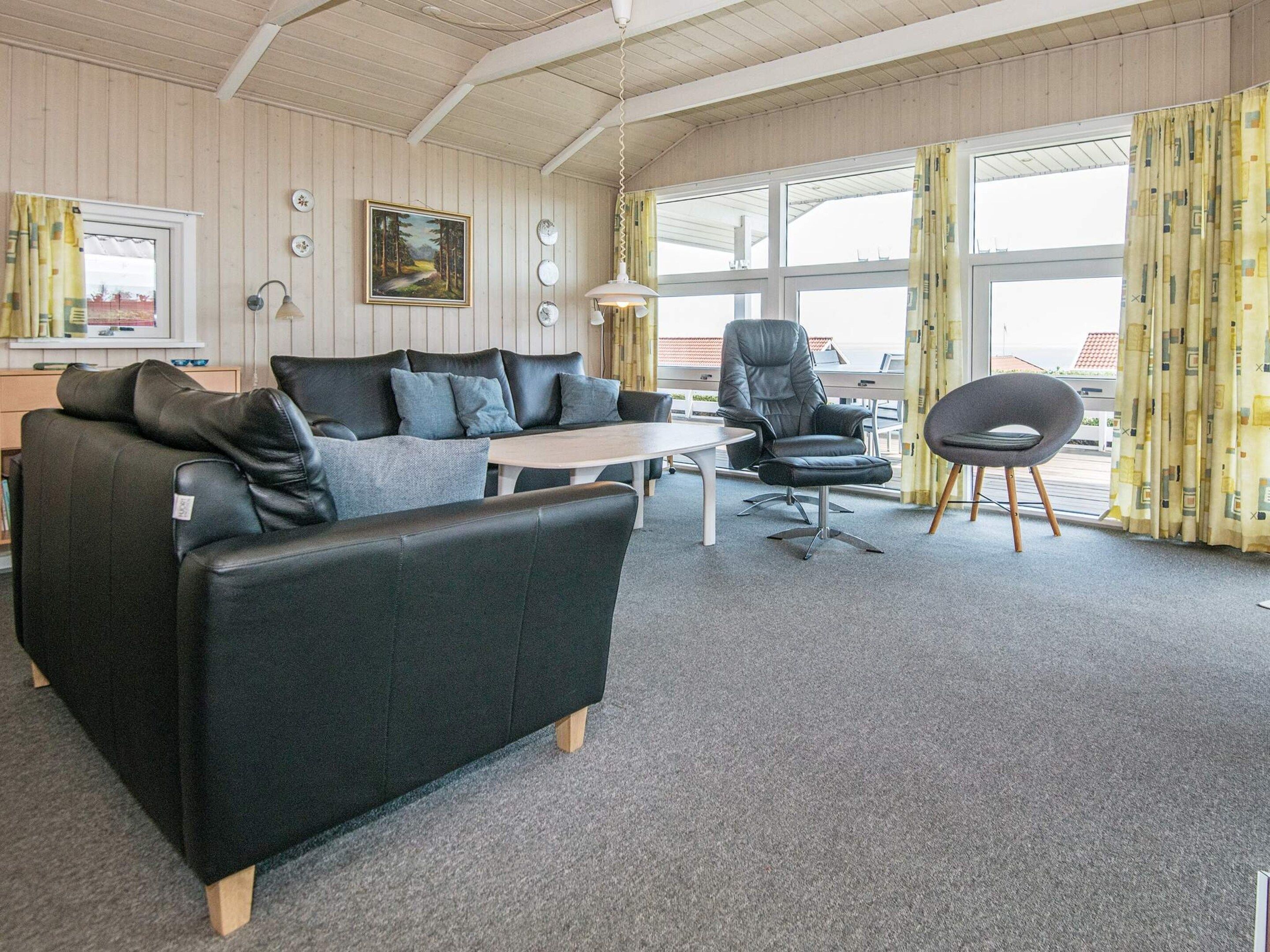 Ein modernes Wohnzimmer mit einer Couch, einem Sessel und einem kleinen Tisch.