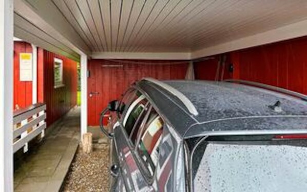 A car parked inside a building with a red exterior and a white ceiling.