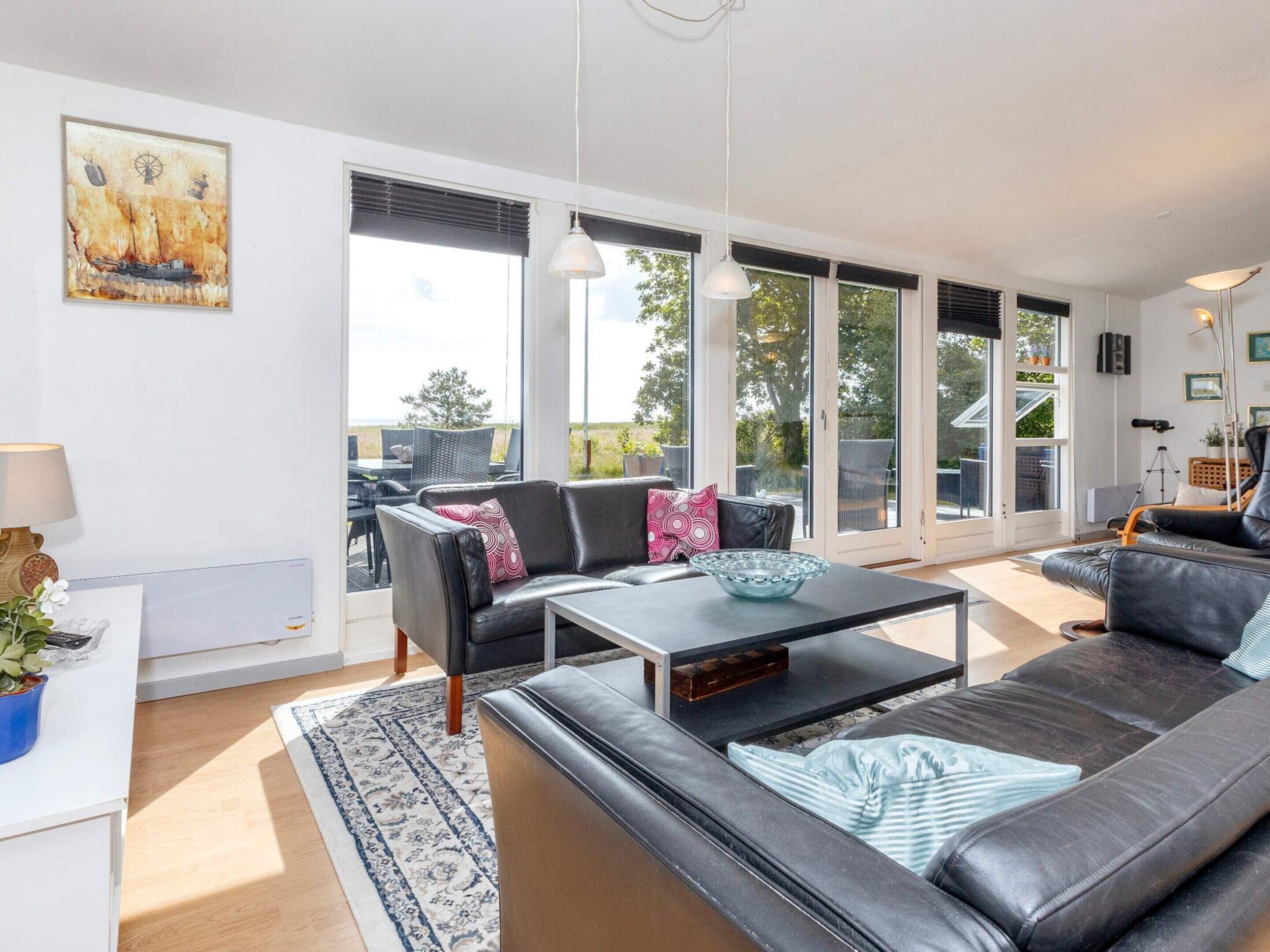A modern living room with a sofa, coffee table, and a painting on the wall.