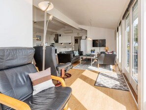 A modern living room with a sofa, chairs, a coffee table, and a television. - 4 Star Holiday Home in Hadsund (Hadsund)