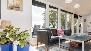 Un salon moderne avec un canapé, une table basse et deux plantes en pot.