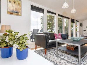 A modern living room with a sofa, a coffee table, and potted plants. - 4 Star Holiday Home in Hadsund (Hadsund)