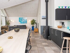 Et moderne køkken med en stor ø, mørke skabe og en sort komfur.