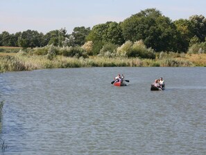 Deux canoës sur une étendue d’eau calme, avec une végétation luxuriante en arrière-plan.
