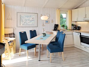 Cocina compacta con comedor, que incluye un mapa en la pared, cafetera y lavavajillas.