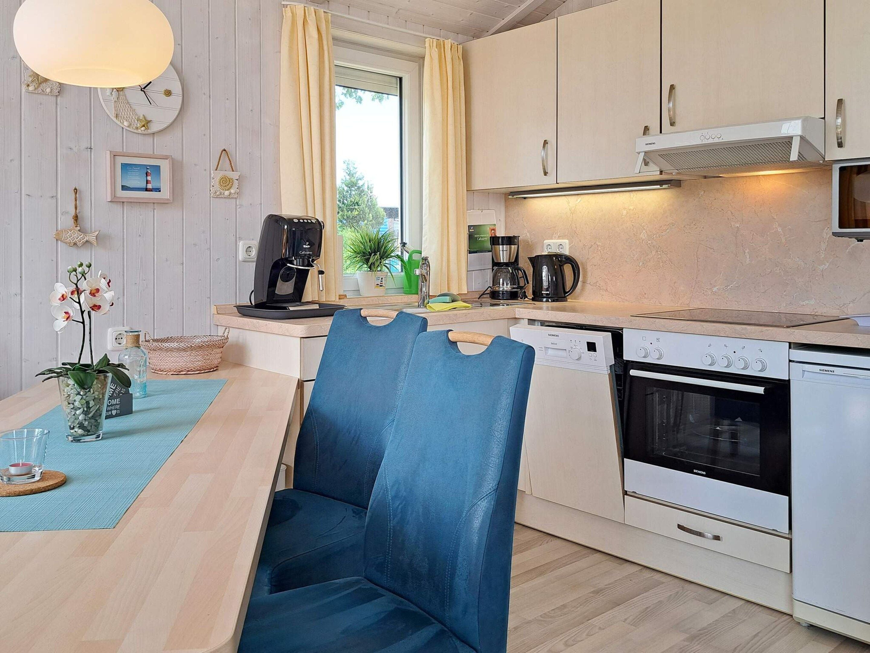 A modern kitchen with a dining area, including a coffee maker, a Siemens dishwasher, and a Siemens oven.