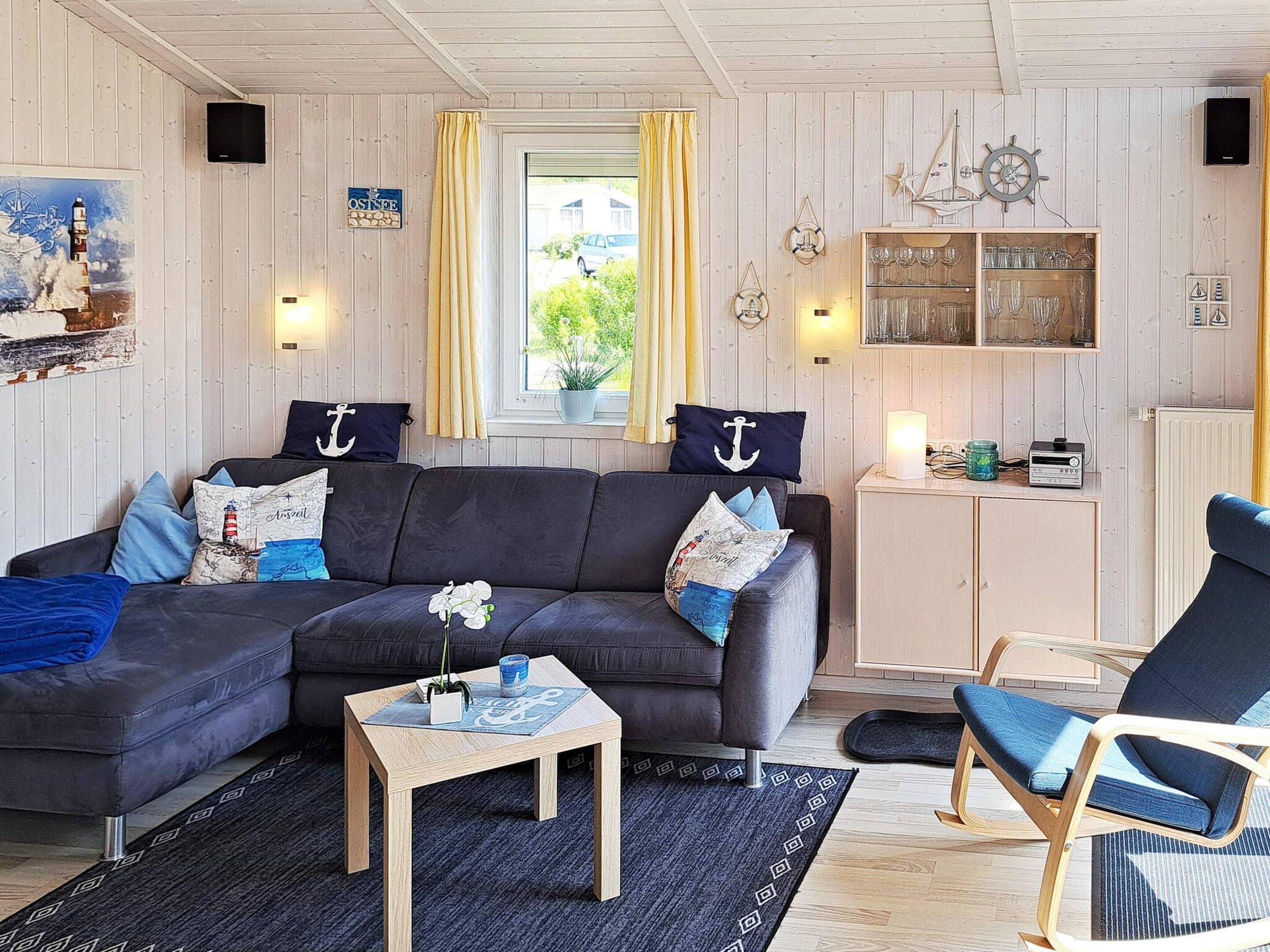 A cozy living room with a dark sofa, a wooden coffee table, and a blue armchair.