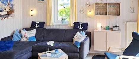A cozy living room with a dark sofa, a wooden coffee table, and a blue armchair.