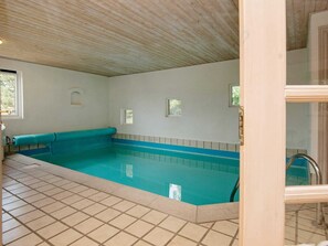 A swimming pool with a tiled floor and a wooden ceiling. - 9 Person Holiday Home in Blavand (Blavand)