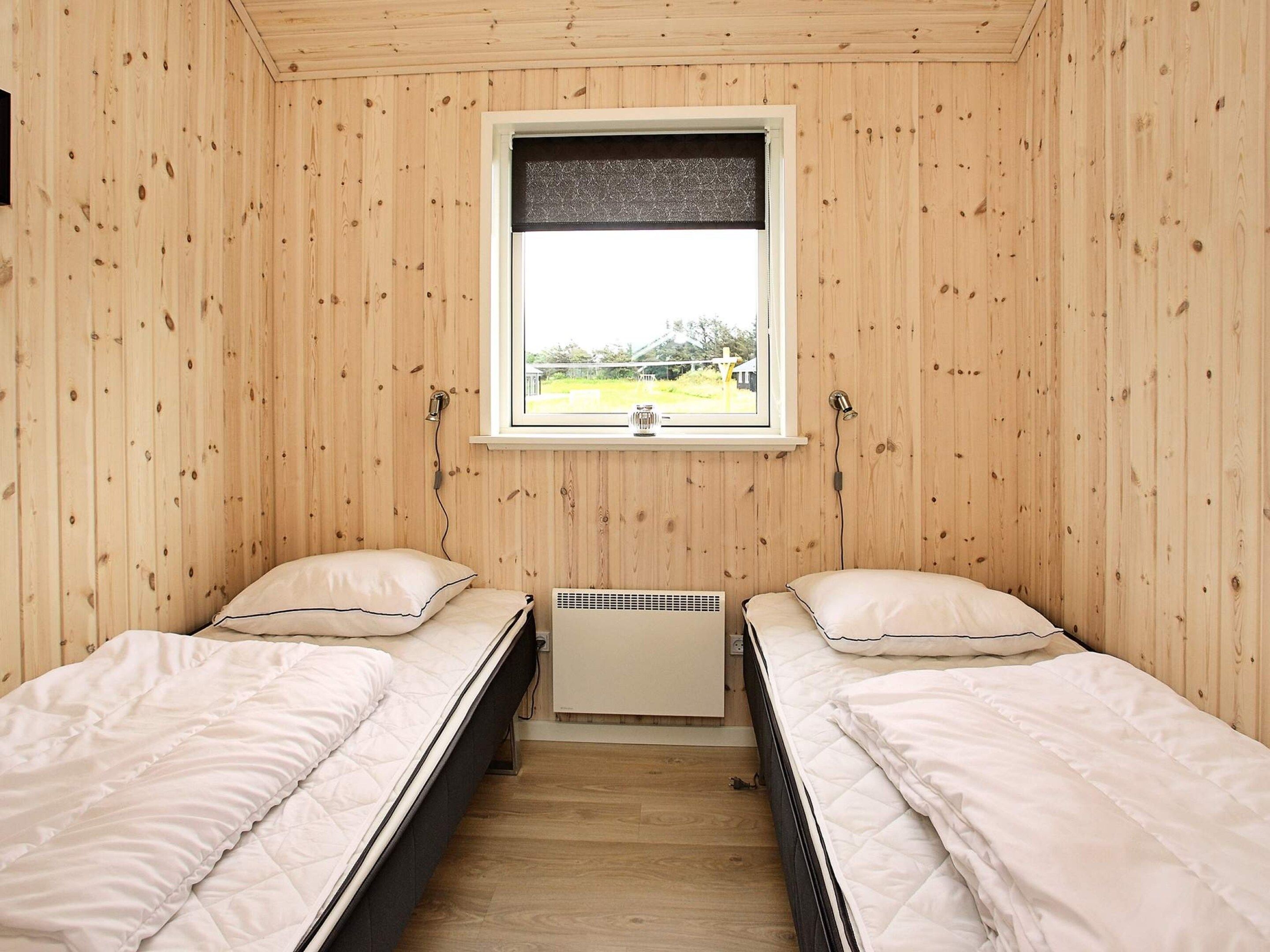 Una habitación con dos camas individuales, una ventana con vistas y un calentador incorporado.