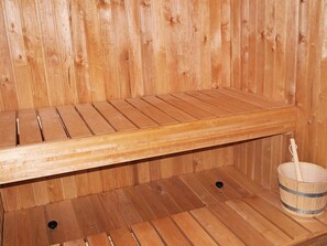 A wooden sauna with a bench and a bucket. - Luxurious Holiday Home in Løkken with Hot Tub & Sauna (Lokken)