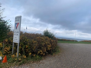 A gravel road leading to a private property named 'KFUM KFUK' with a signboard and a flag. - Pet Friendly Holiday Home in Bogense with Hot Tub (Bogense)