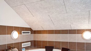 Ein modernes Badezimmer mit freistehender Badewanne, zwei Wandleuchten und einem digitalen Thermometer an der Wand.