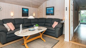 A modern living room with a sectional sofa, a round coffee table, and a ceiling fan. - Classic Retreat in Bork Havn - By Traum Ferienwohnungen (Hemmet)