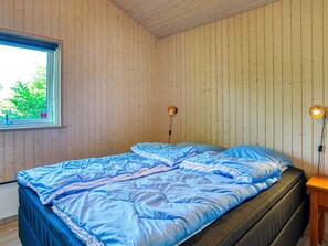 A bedroom with a bed, wooden walls, a window, and two wall-mounted lamps. - 10 Person Holiday Home in Gilleleje-by Traum (Gilleleje)