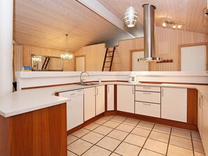 A modern kitchen with wooden cabinets, a stainless steel sink, and a dishwasher. - 4 Star Holiday Home in Gilleleje (Gilleleje)