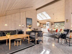 A modern interior with a wooden ceiling, a dining area, a kitchen, and a living room with a sofa and chairs. - Lively Holiday Home in Ålbæk near Sea (Aalbaek)