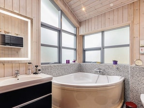 A bathroom with a freestanding bathtub, a sink, and a mirror. - Lively Holiday Home in Ålbæk near Sea (Aalbaek)
