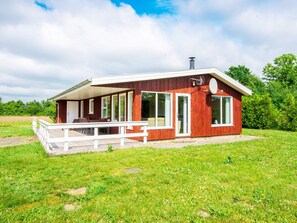 A single-story wooden building with a covered porch, large windows, and a chimney. - 5 Star Holiday Home in Hovborg (Hovborg)