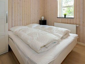 A room with a bed, a window with a view of greenery, and a radiator. - 5 Star Holiday Home in Hadsund (Hadsund)