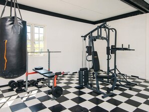 A gym with a checkered floor, weightlifting equipment, and a punching bag. - Luxurious Holiday Home in Jutland with Hot Tub (Aabenraa)