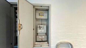 An electrical panel with a label, a door, and a wall-mounted unit. - Luxurious Holiday Home in Jutland with Hot Tub (Aabenraa)