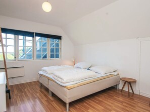 Ein Schlafzimmer mit Bett, Fenster, Schreibtisch und Stuhl.